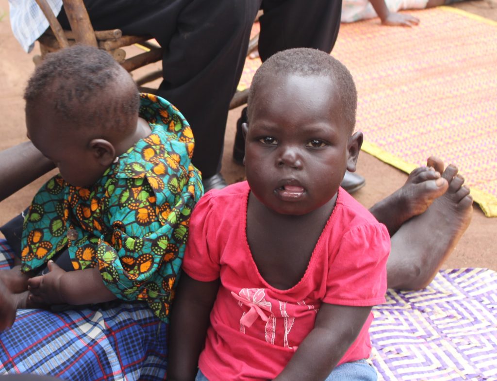 Salva with his sister, outside their family home near Kigumba, Uganda 
